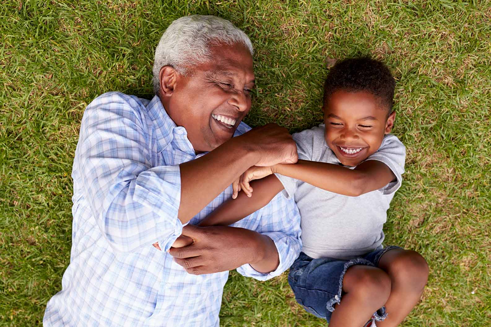 grandfather and grandchild laying on grass smiling three core principles volner financial group bartlett tn
